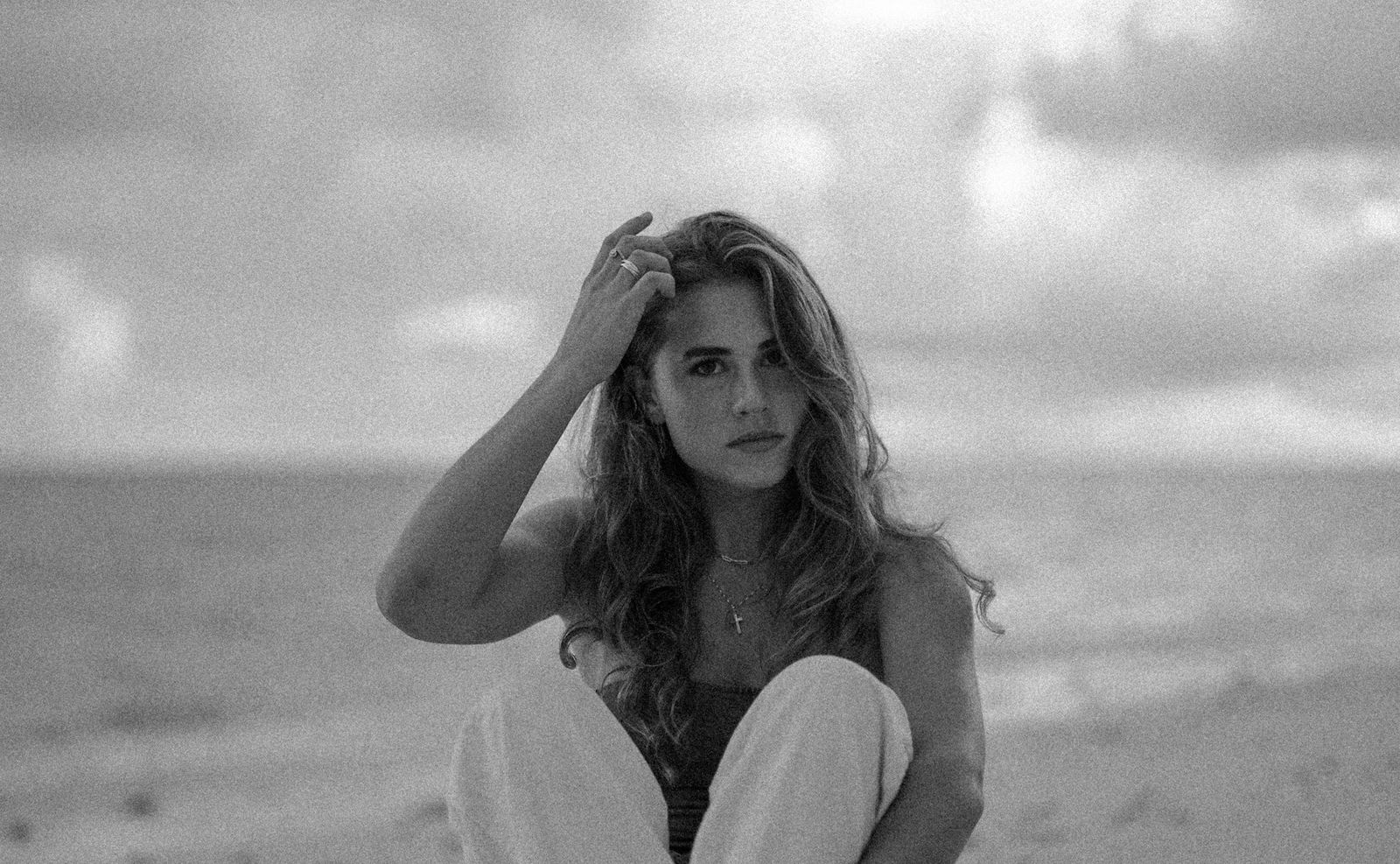 Black and white portrait of a woman on the beach, hand in her hair