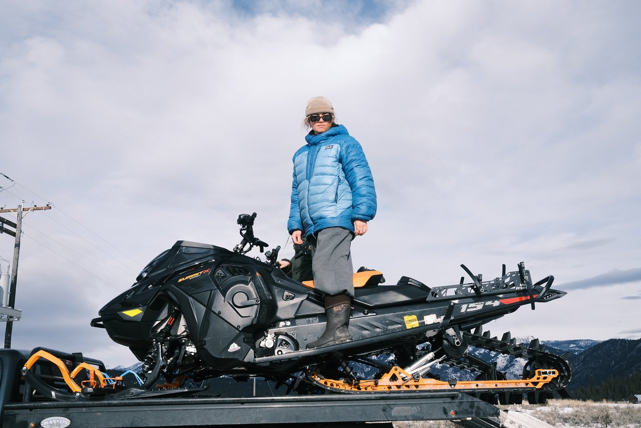 Mckayla standing on a snowmobile