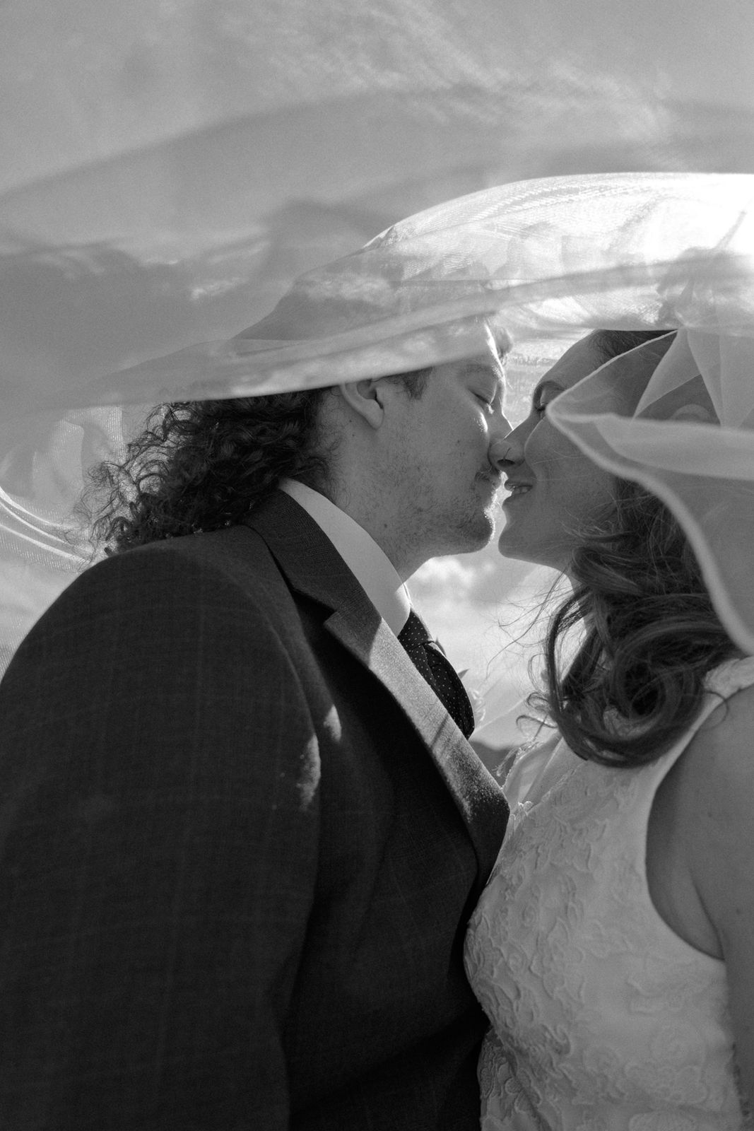 A couple kissing under a veil, black and white